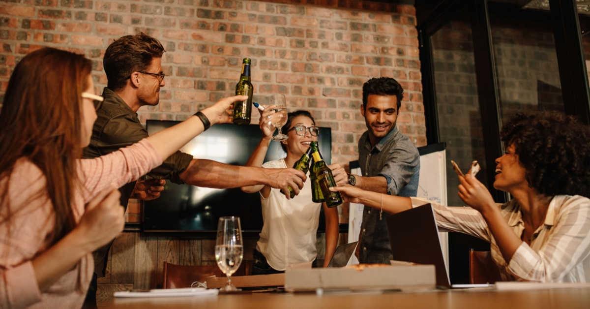group of young business professionals celebrating success with beers